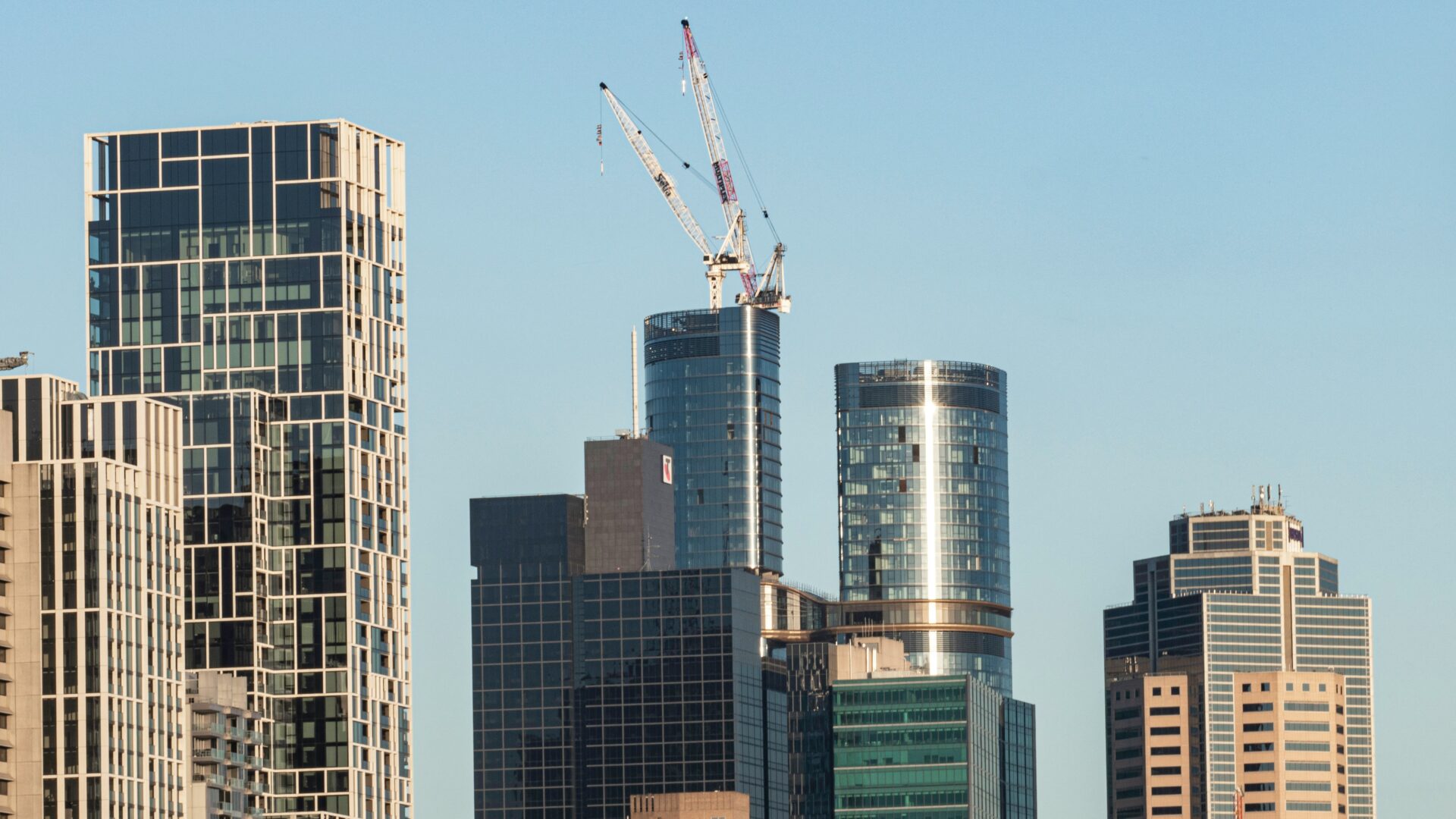 International Investment Trends International investment Australian property development with modern high-rise buildings and construction crane in city skyline.