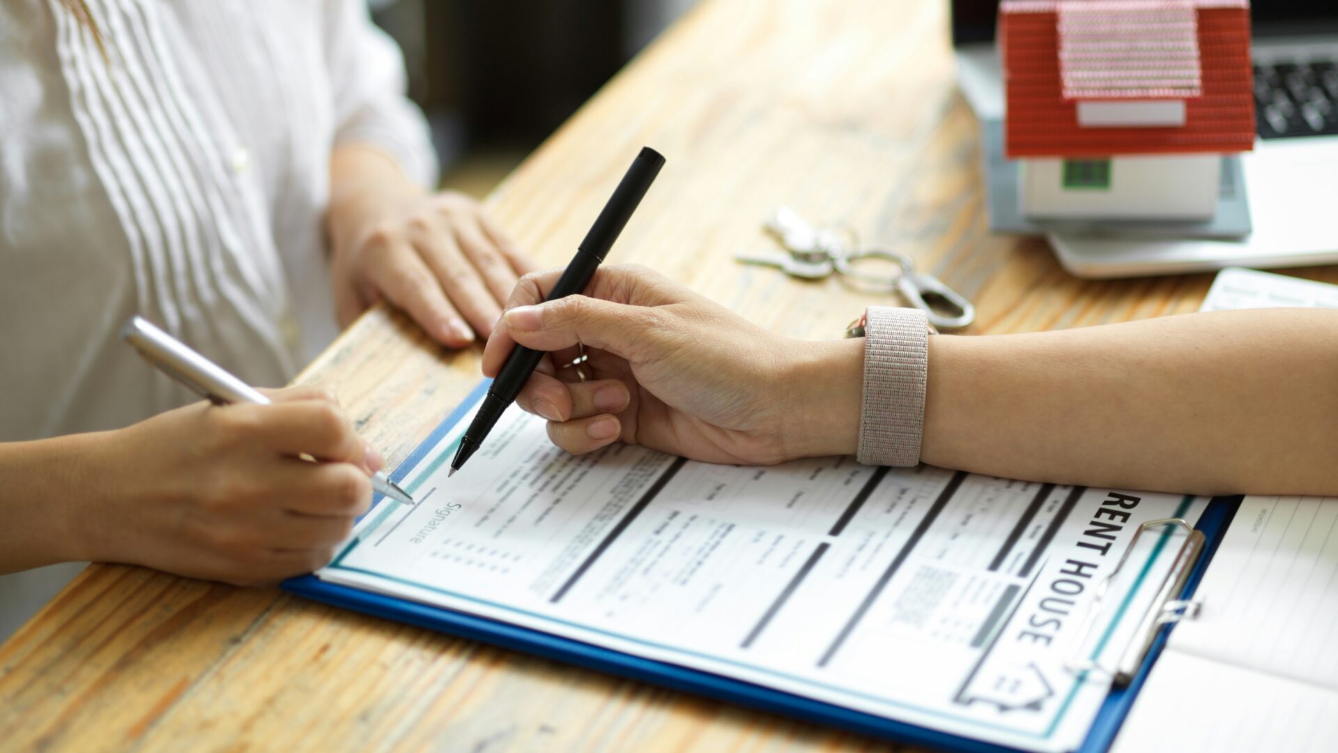 Rental Market Evolution Two people signing a rental agreement at a desk, representing rental market evolution in Australia and modern property management trends.
